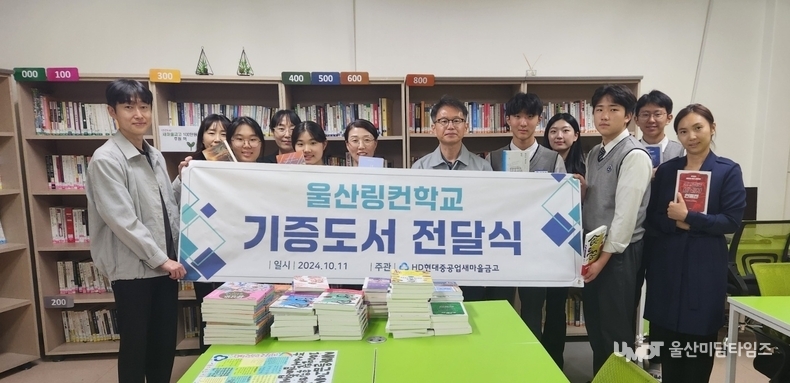 <strong>HD현대중공업새마을금고 임직원과 울산 링컨학교 학생들, 책 100권 기부 행사에서</strong><br>
2024년 10월 11일, 울산 링컨학교에서 진행된 책 기부 행사 후 권태수 이사장과 학생들이 함께 기념 촬영을 하고 있다. 이번 기부는 독서 문화를 장려하고 학생들의 학습 기회를 넓히기 위한 현대중공업 새마을금고의 지역사회 공헌 활동의 일환이다