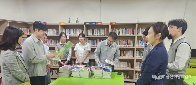 <strong>HD현대중공업새마을금고에서 기부한 책을 책꽂이에 직접 정리하며 학생들과 소통</strong>